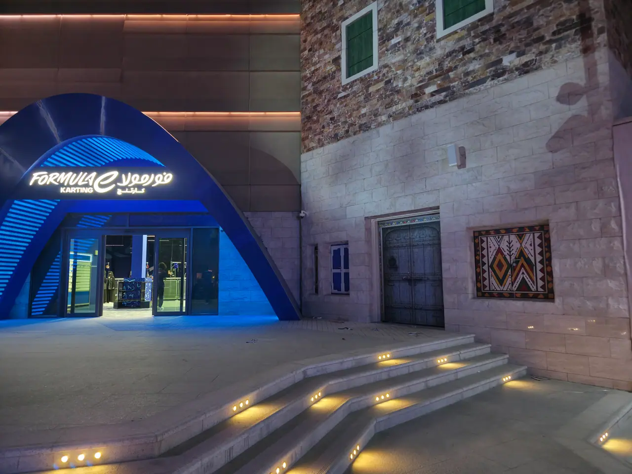 Seven Abha — Destination Graphics & Wayfinding — Heritage graphics beside a lit attraction entrance